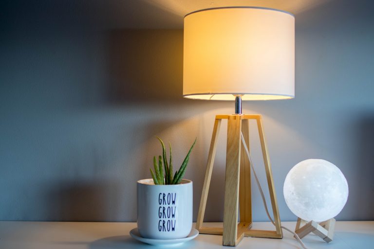 a lamp next to a white container