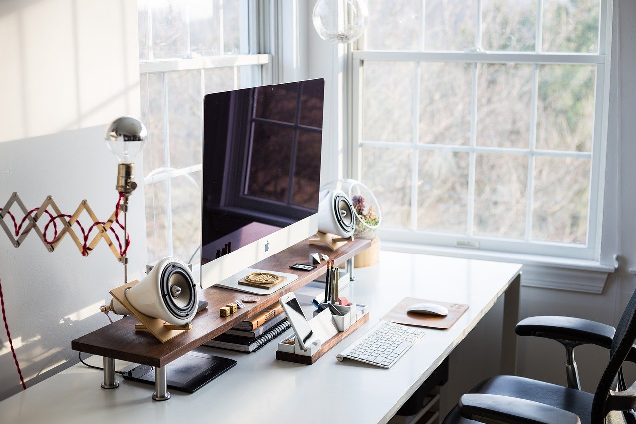 a desk with a computer and a lamp on it