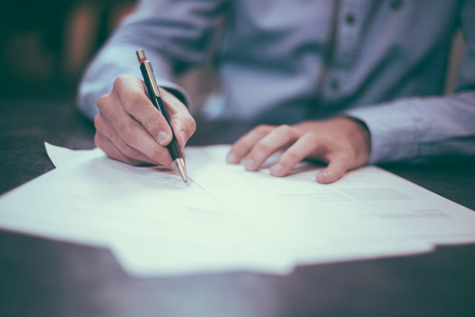 a close-up of a person writing on a paper