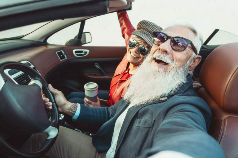 Happy senior couple taking selfie on new convertible car