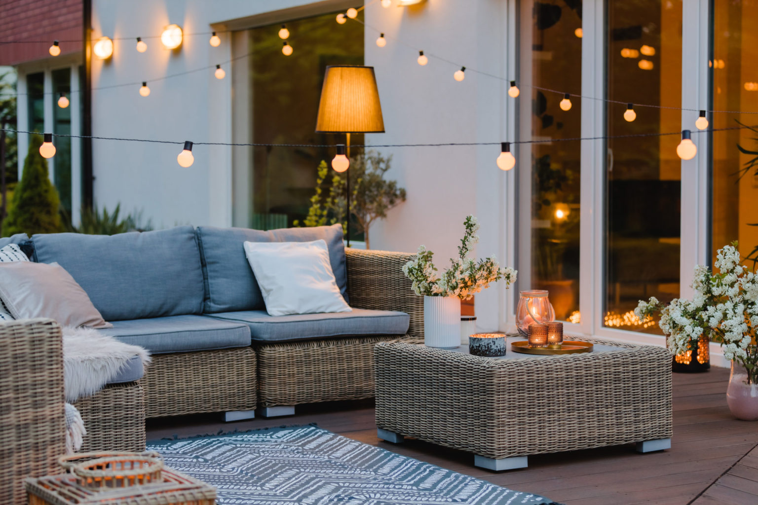 Summer with patio with wicker furniture and lights